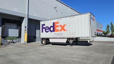 A FedEx Freight trailer is parked at a warehouse dock.