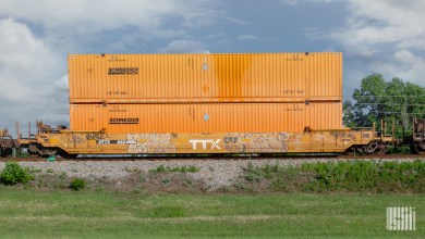 Orange Schneider intermodal containers on a well car