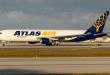 An Atlas Air cargo jet with puprle and yellow markings prepares for takeoff.