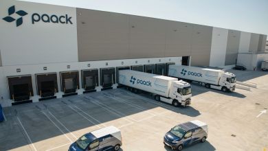 Tractor trailers are parked at dock doors of a Paack warehouse in Europe.