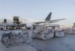 Pallets sit on the tarmac waiting to be loaded in a cargo plane.