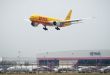 A yellow DHL cargo plane makes its final approach to Bangkok airport in Thailand.