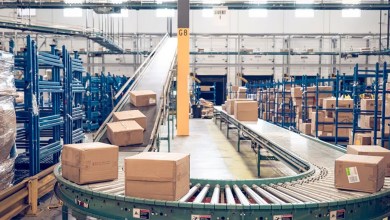 Parcels move on a large conveyor system through a warehouse.