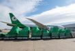 A green EVA Air Cargo jet is seen on ramp with shrink-wrapped pallets on the ground ready for loading.