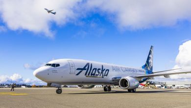 An Alaska Air Cargo jet sits on the tarmac on a sunny day at LAX airport.