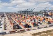 Cargo containers stacked at a busy U.S. port terminal as Section 301 forced labor tariffs of 10% to 12.5% take effect on imports from 60 economies