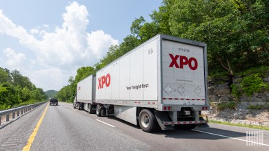 two XPO trailers being pulled on a highway