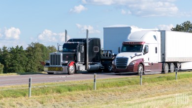 two tractor-trailers side by side on a highway