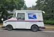 A side view of a U.S. Parcel Service delivery van stopped on a side of the road.