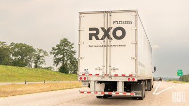 a rearview of an RXO dryvan trailer on a highway