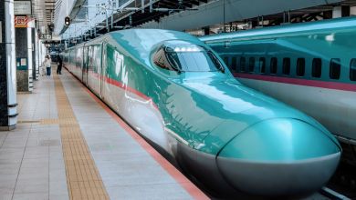 A front view of an aqua-colored Shinkansen bullet train in Japan.