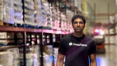 DeepFabric CEO Kalyan Kommineni stands in a Kenco warehouse aisle among pallet racks