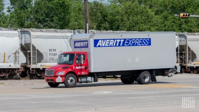 An Averitt liftgate truck near a passing train