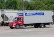 An Averitt liftgate truck near a passing train