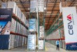 An inside view of a Ceva Logistics warehouse with rows of filled storage racks.