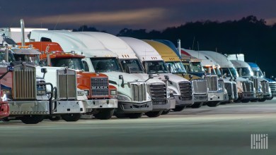 Fleet of semi-trucks lined up at dusk, illustrating carriers and small fleets using freight AI agents and TMS technology