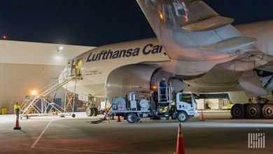 A ground view of a tank truck fueling a Lufthansa Cargo jet at night.