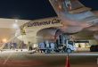 A ground view of a tank truck fueling a Lufthansa Cargo jet at night.
