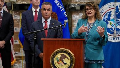 Law enforcement officials stand at a podium to discuss efforts to stop trade fraud.