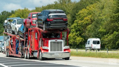 a fully loaded auto hauler on a highway