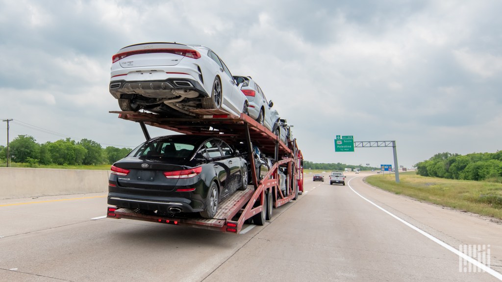 a loaded auto hauler on a highway