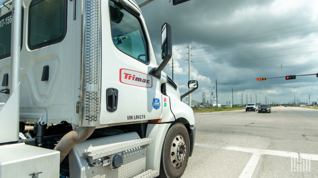 a white Trimac daycab at a stoplight