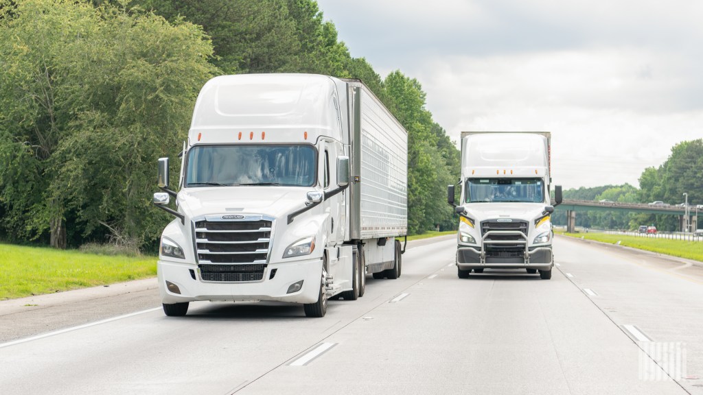 front view of two white tractor-trailers on a highway