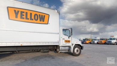 a parked Yellow straight truck with other Yellow trucks parked in background