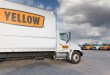 a parked Yellow straight truck with other Yellow trucks parked in background