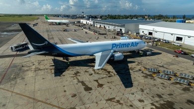A blue-tailed Amazon cargo plane at a small airport as seen from above.