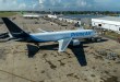 A blue-tailed Amazon cargo plane at a small airport as seen from above.