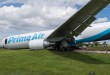 View of Amazon Air cargo jet nose down in grass field after an accident.