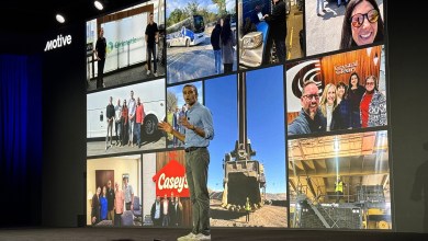 Motive CEO Shoaib Makani on the Vision 26 stage in front of a wall of customer fleet and job-site photos