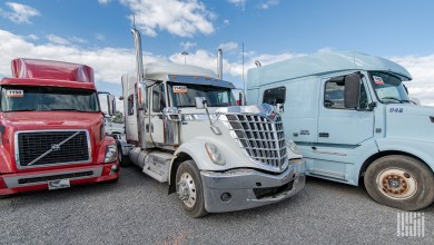 Class 8 sleeper tractors parked in a dealer lot awaiting truck financing and resale