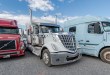 Class 8 sleeper tractors parked in a dealer lot awaiting truck financing and resale