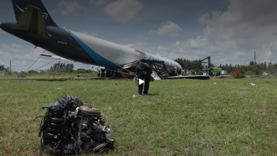 An Amazon Prime Air, nose down with a damaged engine piece sitting in a field after an accident at Miami airport.
