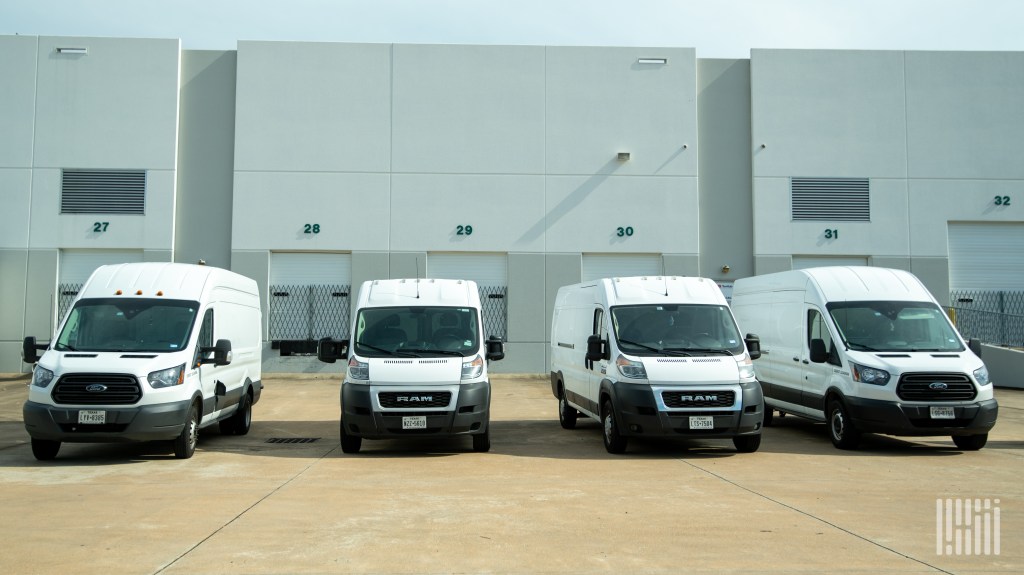 delivery vans in front of dock doors at a warehouse