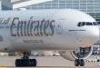 A white Emirates 777 jet facing the camera.