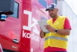 A driver holding an iPad in front of a Kodiak AI autonomous truck. PrePass and Kodiak AI connect autonomous truck inspection records to state roadside enforcement