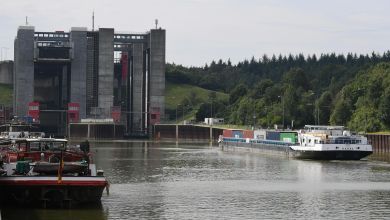 A barge approaches a set of locks on a river in Germany.