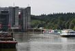 A barge approaches a set of locks on a river in Germany.