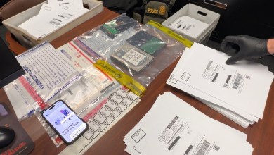 Hand of a police officer in a rubber glove is seen laying out evidence on a table.