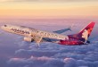 Image of a Hawaiian Air Cargo jet flying above the clouds.