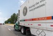 a side view of an Old Dominion trailer being pulled by an OD tractor on a highway