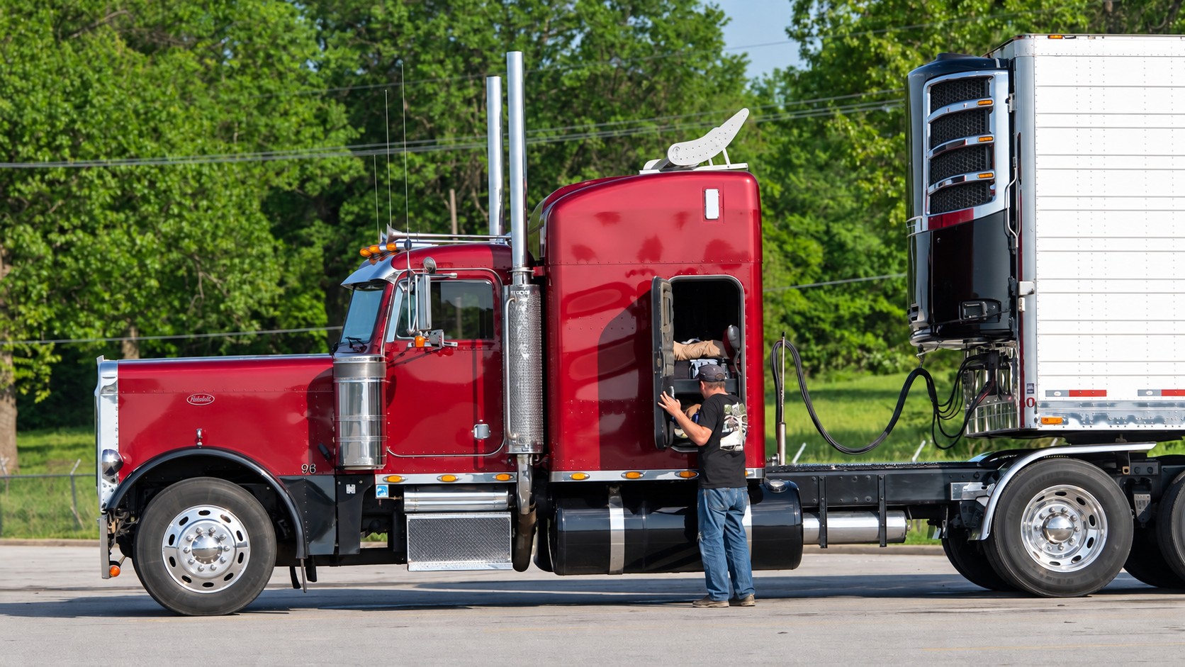 A federal complaint says Trancasa USA refused to hire a 64-year-old driver with a clean record after an insurer allegedly rejected his application. A truck driver stands beside a tractor-trailer in an archive photo. (Photo: Jim Allen/FreightWaves)