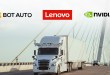 Autonomous truck with roof sensors crosses a bridge under Bot Auto, Nvidia and Lenovo logos for their AD1 computer deal