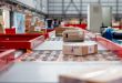 Parcels moving on a conveyor belt in a warehouse.