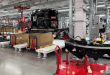 Tesla Semi cab chassis on the assembly line inside Tesla’s Sparks, Nevada plant, with production equipment, pallets, and overhead systems visible.