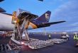 Pallets are loaded through the rear cargo door of a UPS cargo jet.