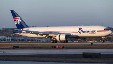 A blue-tailed Amerijet cargo jet moves on the ground at an airport.